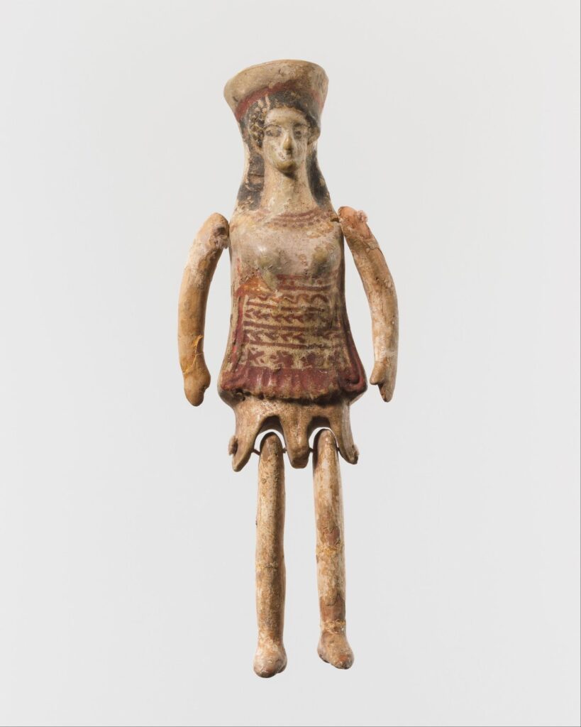 Painted Greek terracotta figurine with movable arms and legs, wearing a tall headdress and short tunic