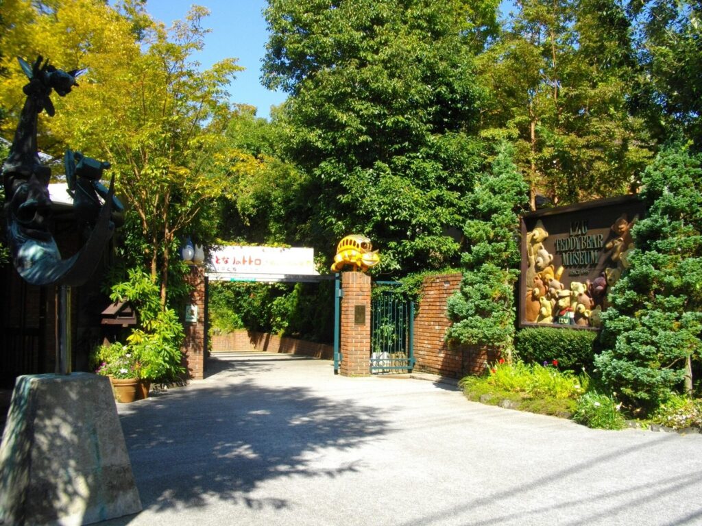 Tree-lined entrance gate and sign of the Izu Teddy Bear Museum in Ito, Japan